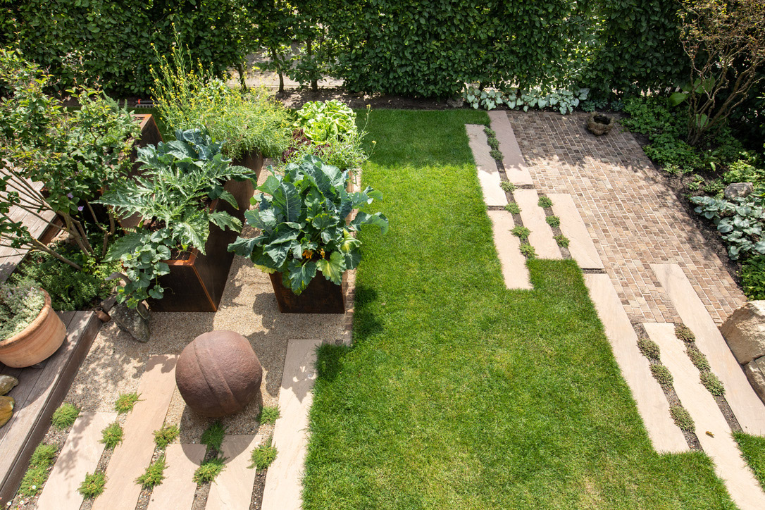 Moderner Küchengarten, Gemüse im Cortenstahl-Beet, Natursteinpflasterung, Trockenmauer und dekoratives Kunsthandwerk im Garten